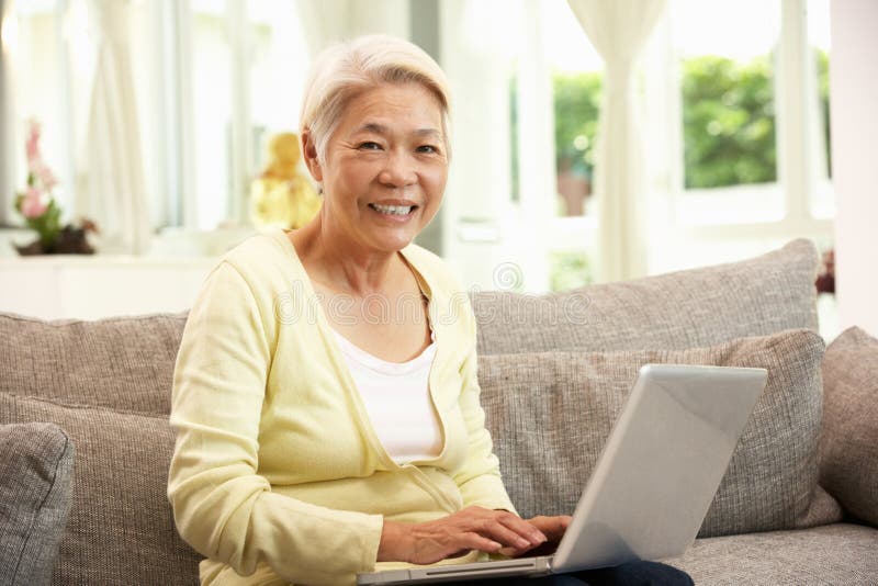 Używać Laptop starsza Chińska Kobieta Podczas gdy Relaksujący