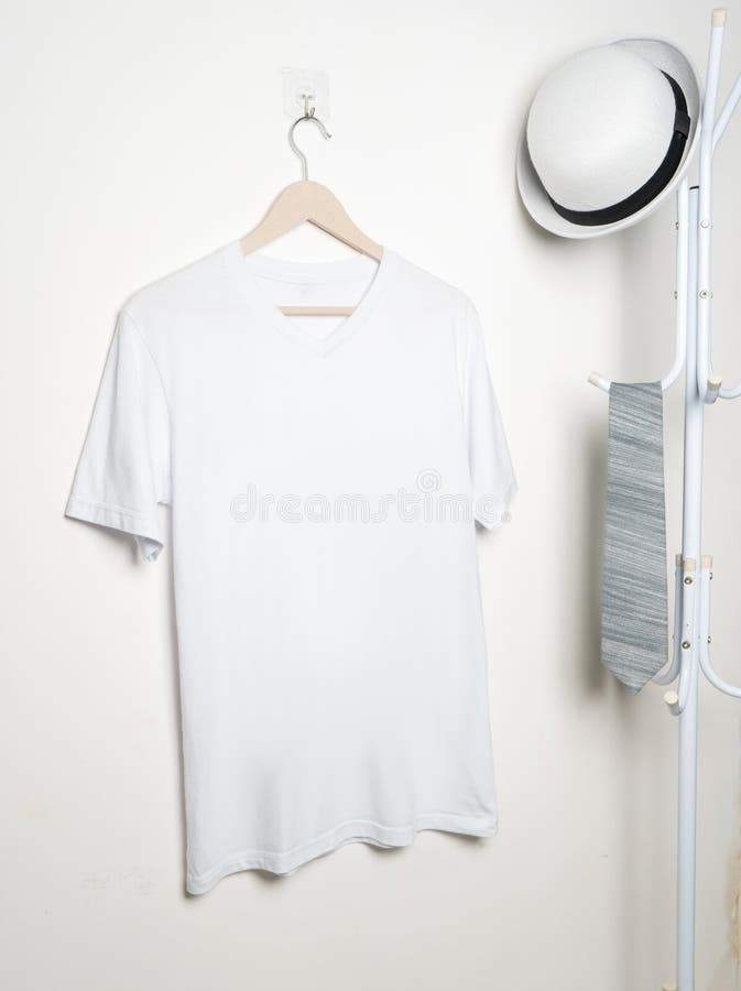 A v neck shirt hanged on the hook at the wall with minimalist decoration