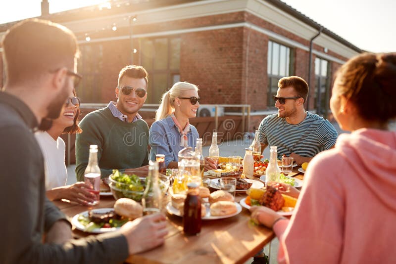 V?nner som har matst?llen eller bbq-partiet p? tak royaltyfri fotografi V?nner som har matst?llen eller bbq-partiet p? tak royaltyfri fotografi