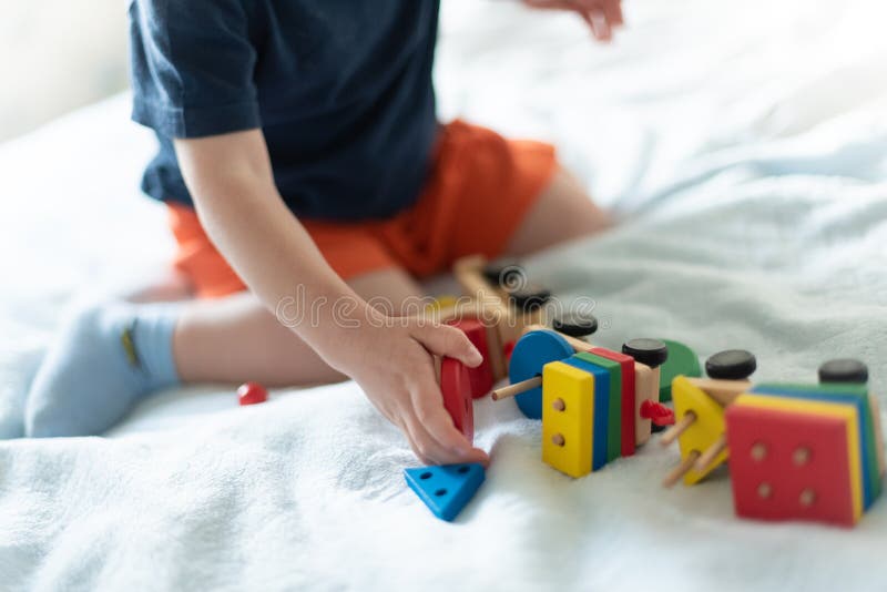 V?xa upp och ungefritidbegrepp Ett barn som spelar med ett kul?rt tr?drev Ungen bygger konstrukt?rn utan framsidan arkivfoton V?xa upp och ungefritidbegrepp Ett barn som spelar med ett kul?rt tr?drev Ungen bygger konstrukt?rn utan framsidan arkivfoton