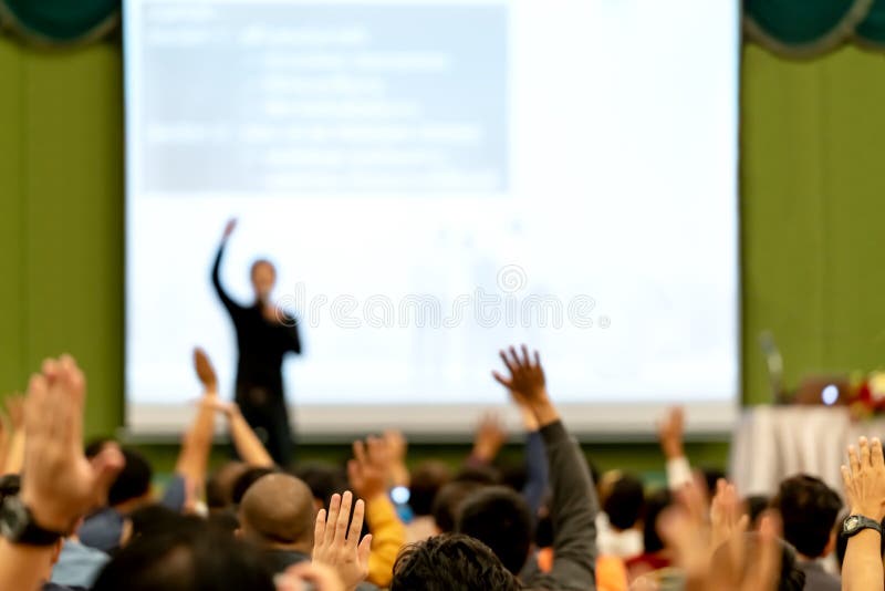 Vaag van achtermeningspubliek in conferentiezaal of seminarieruimte De spreker is brainstorming, motieventoespraak bij Vaag van achtermeningspubliek in conferentiezaal of seminarieruimte De spreker is brainstorming, motieventoespraak bij