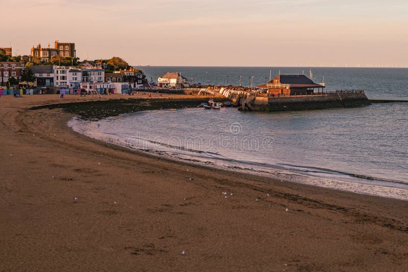 Vacaciones de sol y playa británicas y relájese en las vacaciones de verano idea conceptual con el amanecer sobre el mar del muell foto de archivo libre de regalías