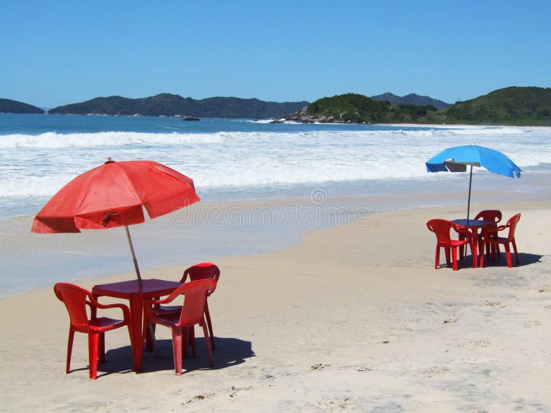 Two tables with chairs and sunshade on a tropical beach. Two tables with chairs and sunshade on a tropical beach