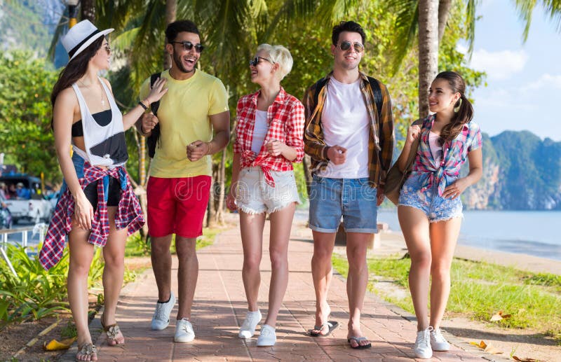 Vacances d'été parlantes de marche de mer de vacances de plage de groupe des jeunes d'amis tropicaux de palmiers images libres de droits Vacances d'été parlantes de marche de mer de vacances de plage de groupe des jeunes d'amis tropicaux de palmiers images libres de droits