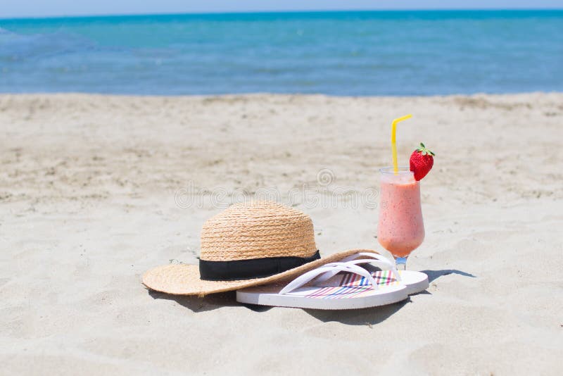 Vacances d'été sur le bord de la mer Verre de cocktail, de chapeau et de lunettes de soleil frais sur la plage image libre de droits Vacances d'été sur le bord de la mer Verre de cocktail, de chapeau et de lunettes de soleil frais sur la plage image libre de droits
