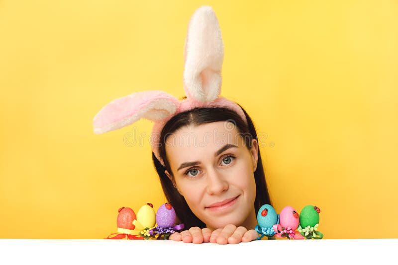 Vacances fête du printemps. joyeuse jeune femme avec des petits oeufs peints célébrant la journée de Pâques dans les oreilles de l photo libre de droits