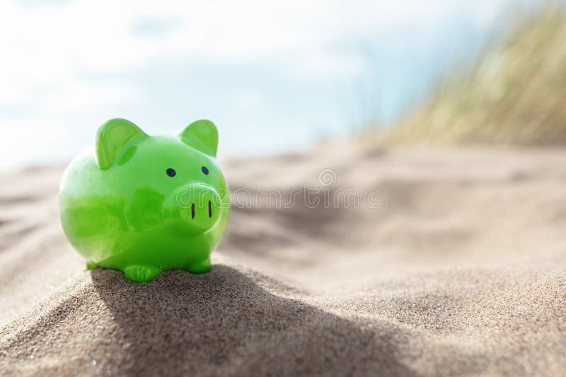Vacances été green piggy banque sur la plage photos libres de droits
