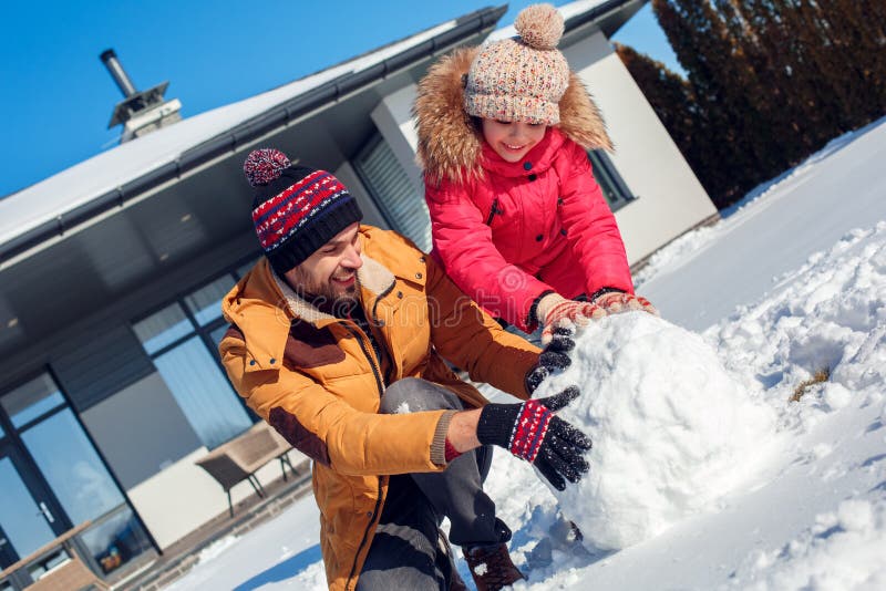Vacanza di inverno Aria aperta di tempo della famiglia vicino alla palla di neve di rotolamento del tubo flessibile per il primo immagini stock libere da diritti Vacanza di inverno Aria aperta di tempo della famiglia vicino alla palla di neve di rotolamento del tubo flessibile per il primo immagini stock libere da diritti