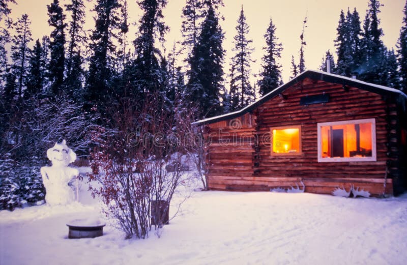 Vacanza illuminata accogliente di inverno della cabina di ceppo del pupazzo di neve immagine stock libera da diritti Vacanza illuminata accogliente di inverno della cabina di ceppo del pupazzo di neve immagine stock libera da diritti