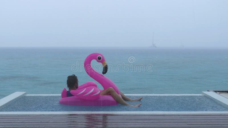 In vacanza pioggia divertente video di un uomo su flamingo flop in piscina di lusso