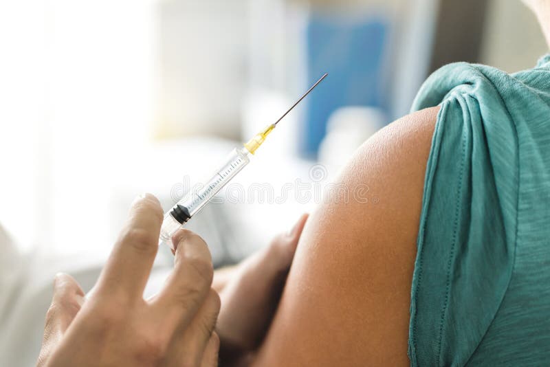 Vaccin- eller influensaskott i injektionvisare Doktor som arbetar med patients arma