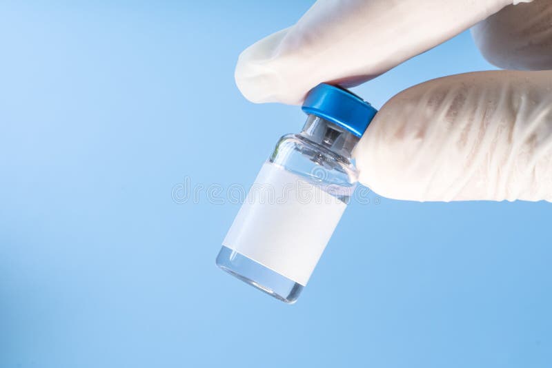 Vaccine in Vial with Syringe on Blue Background. Blank White Label for