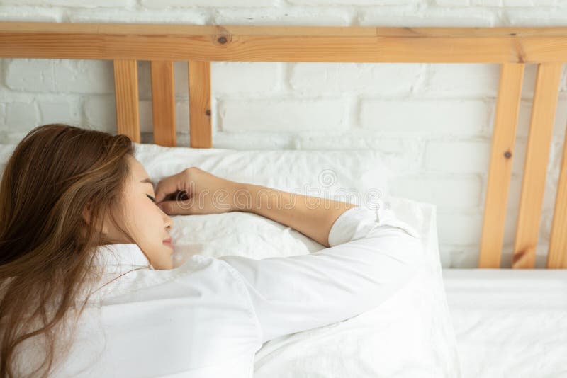 Vacker, attraktiv, asiatisk kvinna sover och söt dröm om sängen i sovrummet arkivbilder
