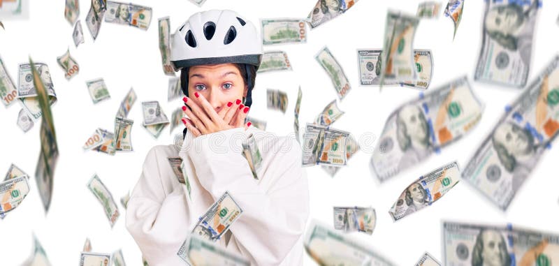 Vacker brunettkvinna som bär cykelhjälm och sportiska kläder chockade som täcker munnen med händer för misstag royaltyfri fotografi