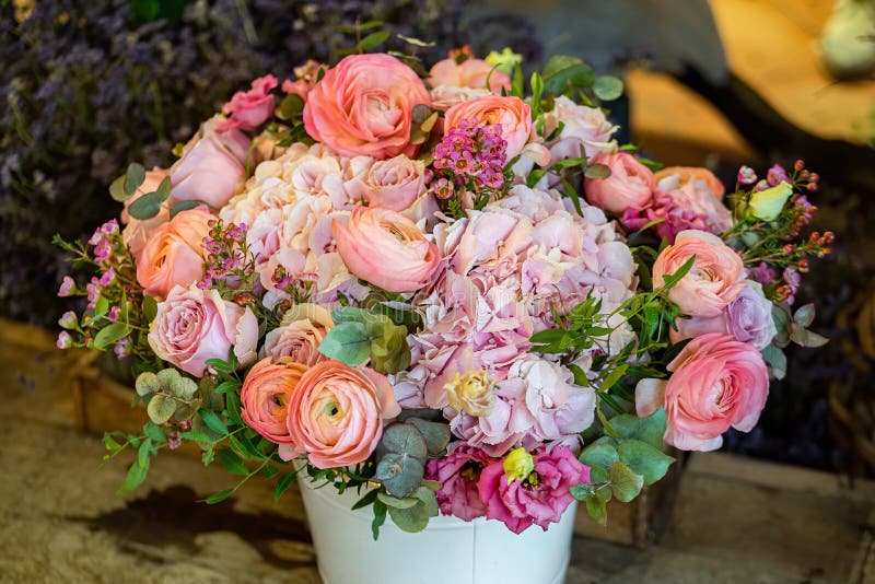 Vacker bukett med flera färger av blandade rosor och andra blommor i en butik. Färska snittblommor som placeras i vita blomkrukor arkivfoto