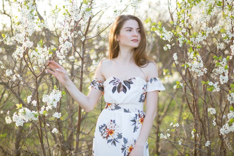 Vacker flicka bland körsbärsblommor på en solig vårdag royaltyfri foto