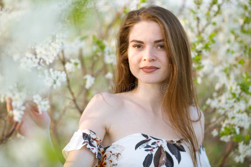 Vacker flicka bland körsbärsblommor på en solig vårdag arkivbilder
