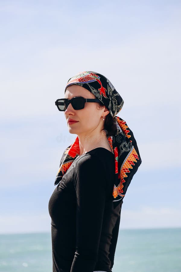 Vacker flicka med silke-scarf på stranden i fin fotografering för bildbyråer