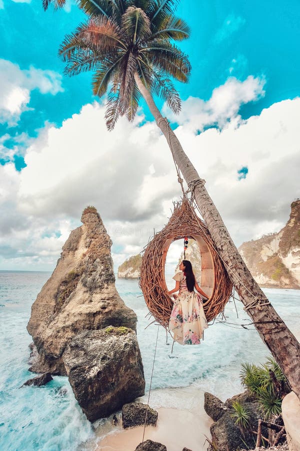 Vacker flicka på vingpalmer på stranden på Daimond strand nusa penida ö bali indonesia royaltyfria foton
