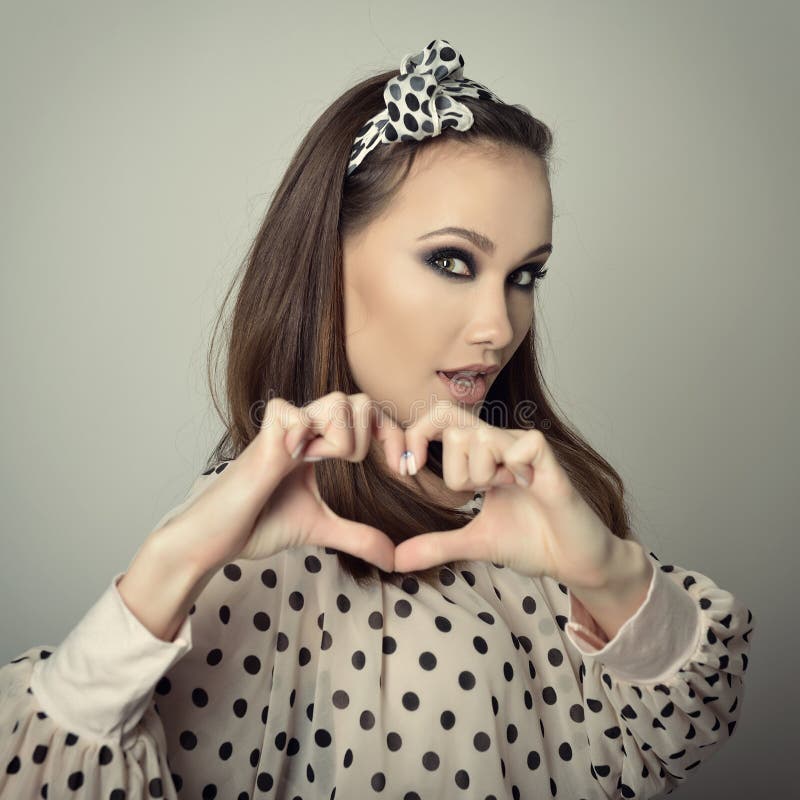 Vacker flicka som visar hjärta med sin handscheartbrytare. tempress. lockande kvinna. Anteckning av en rolig ung modekvinna royaltyfri bild
