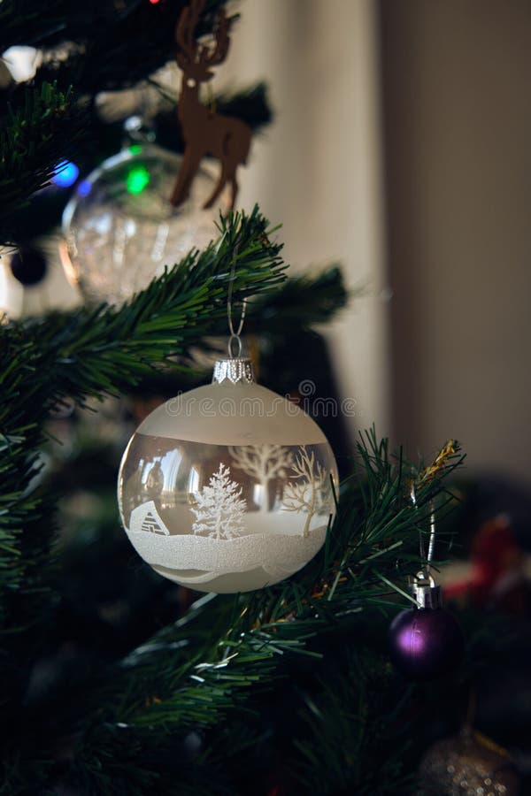 Vacker glaskula på ett nytt julgransträd. En vacker vit glasboll på ett nytt julgransträd