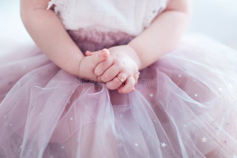 Vacker gyllene fingerring på små händer på den ynkliga prinsessans flicka arkivbild