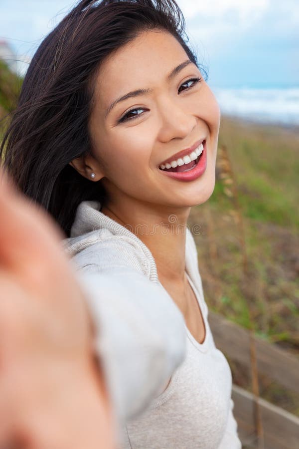 Vacker kinesisk asiatisk ung kvinnlig flicka som skrattar med perfekta tänder