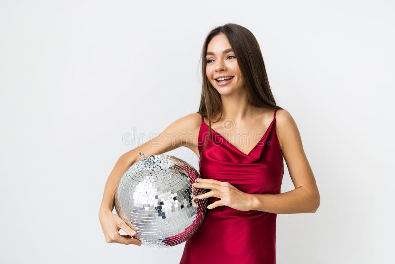 Vacker kvinna i klänning med discoboll som klär sig på vit bakgrund fotografering för bildbyråer