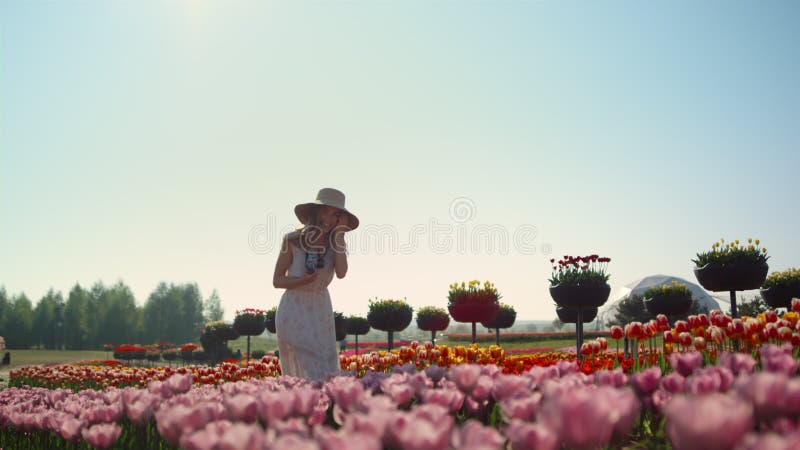 Vacker kvinna som skrattar i vårblommans trädgård. söt dam som går på ängen.