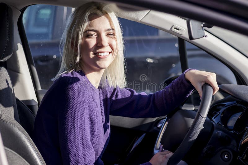 Vacker, lycklig kvinna i den nya bilen royaltyfri foto