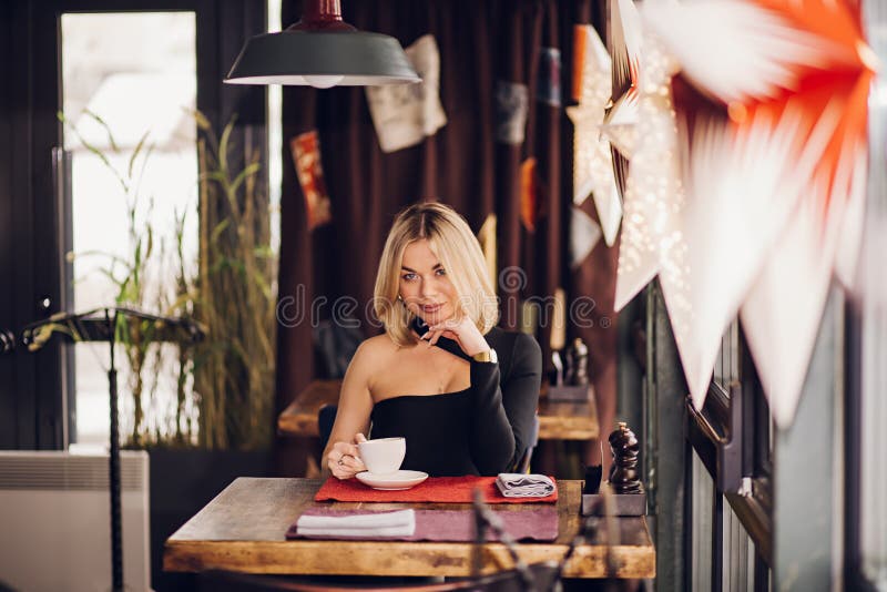 Vacker söt flicka i caféet arkivfoto