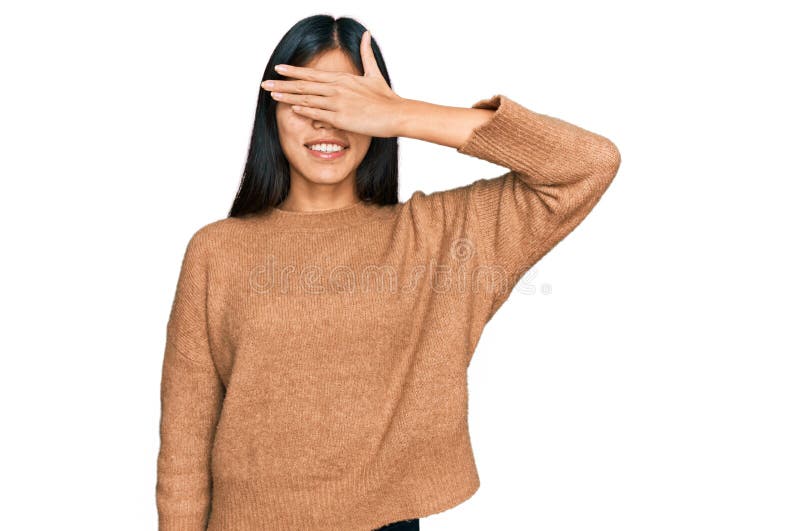 Vacker ung asiatisk kvinna som bär tillfällig vinter svettare som leker och skrattar med hand på ansiktets täckande ögon för överr royaltyfria bilder