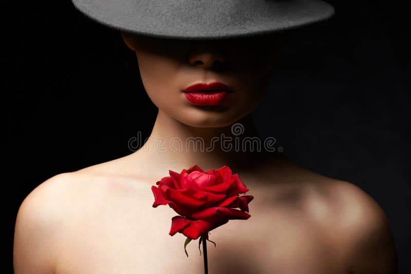 Vacker ung kvinna i hatt och blomma. underbar flicka med makeup och röd ros. skönhet