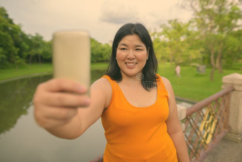 Vacker övervikt som en kvinna avslappnar vid parken i staden Bangkok thailand fotografering för bildbyråer