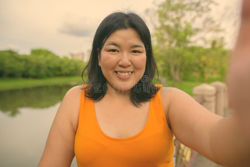 Vacker övervikt som en kvinna avslappnar vid parken i staden Bangkok thailand royaltyfri foto