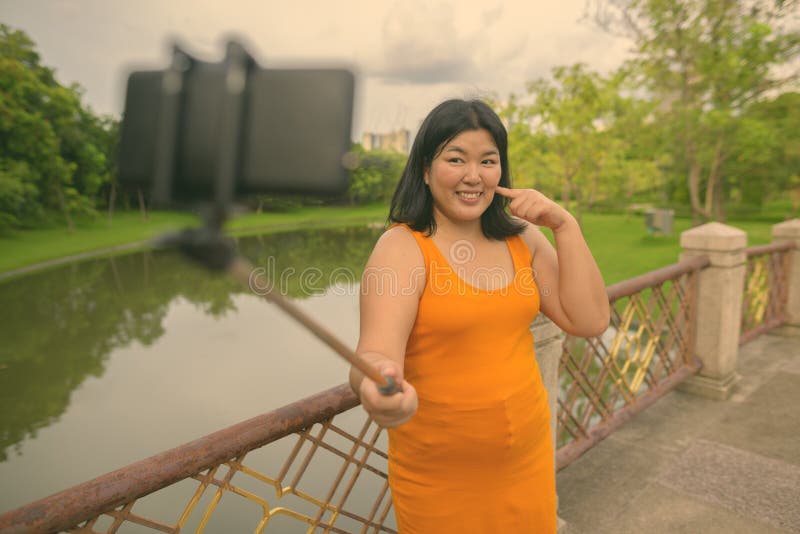 Vacker övervikt som en kvinna avslappnar vid parken i staden Bangkok thailand royaltyfri foto