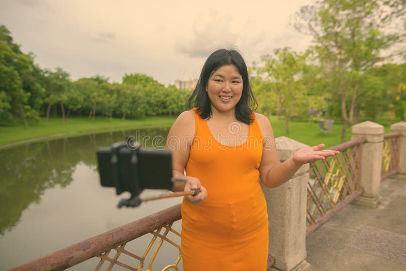 Vacker övervikt som en kvinna avslappnar vid parken i staden Bangkok thailand royaltyfria foton