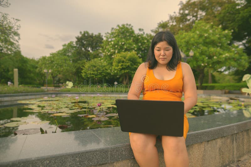 Vacker övervikt som en kvinna avslappnar vid parken i staden Bangkok thailand fotografering för bildbyråer