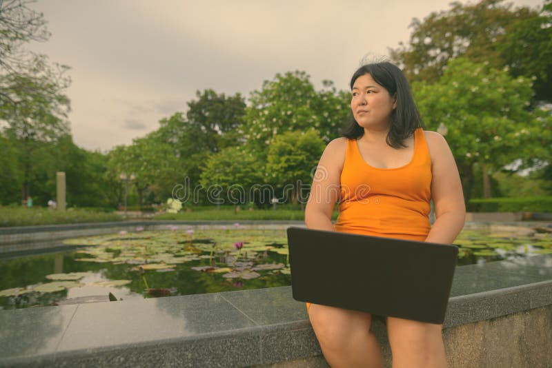 Vacker övervikt som en kvinna avslappnar vid parken i staden Bangkok thailand arkivbilder