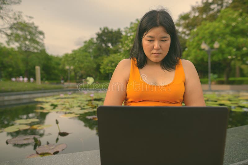 Vacker övervikt som en kvinna avslappnar vid parken i staden Bangkok thailand arkivfoto