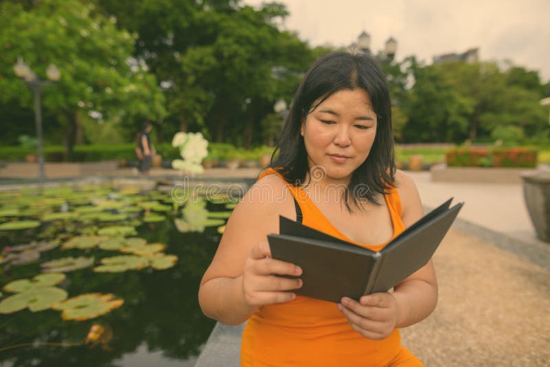 Vacker övervikt som en kvinna avslappnar vid parken i staden Bangkok thailand arkivfoto