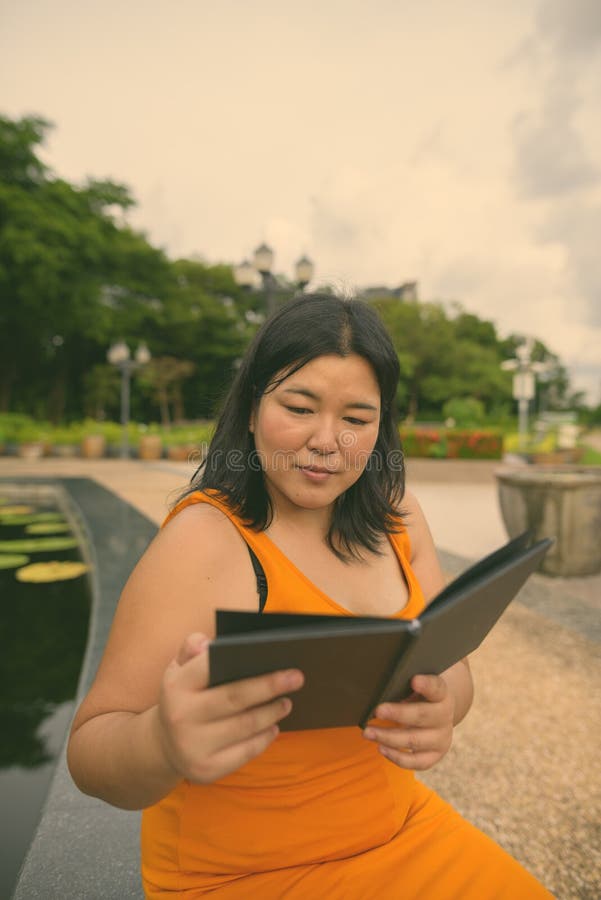 Vacker övervikt som en kvinna avslappnar vid parken i staden Bangkok thailand royaltyfri foto