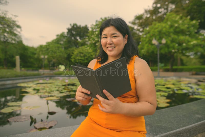 Vacker övervikt som en kvinna avslappnar vid parken i staden Bangkok thailand royaltyfri fotografi
