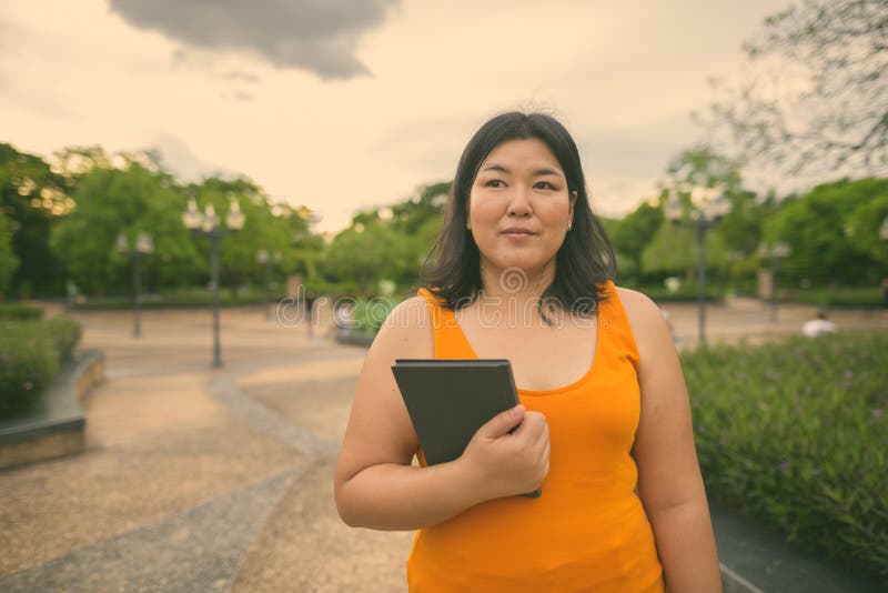 Vacker övervikt som en kvinna avslappnar vid parken i staden Bangkok thailand arkivfoton