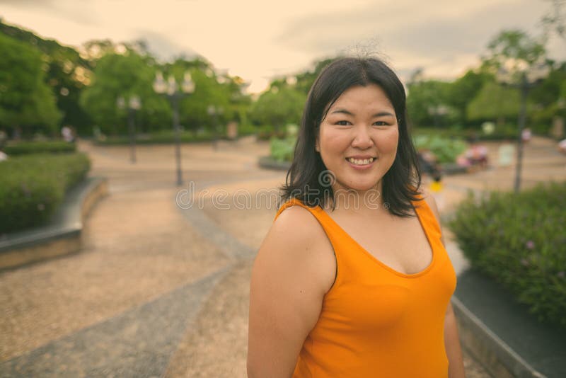 Vacker övervikt som en kvinna avslappnar vid parken i staden Bangkok thailand royaltyfria foton