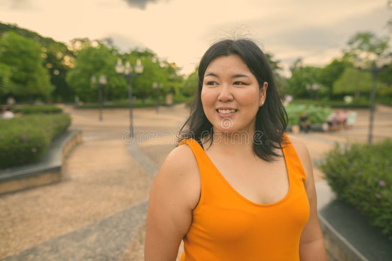 Vacker övervikt som en kvinna avslappnar vid parken i staden Bangkok thailand arkivbild