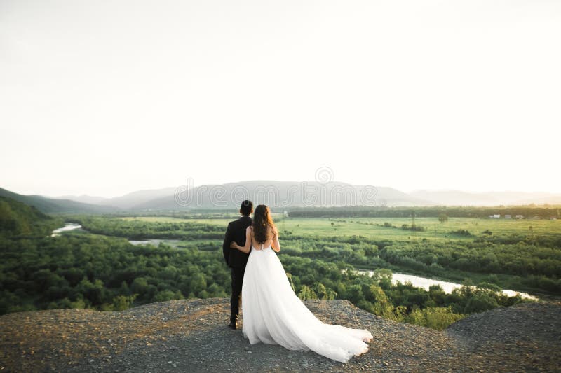 Vackert bröllop-par som stannar över vackert landskap royaltyfri bild