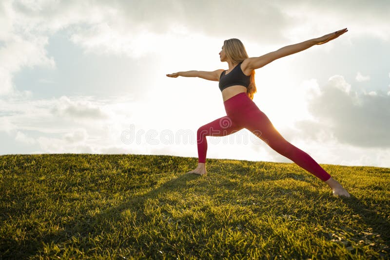 Vackert Woman Yoga Exercise Pose Warrior 2 Asana Position Tranquil Sunset - Silhouette Background fotografering för bildbyråer Vackert Woman Yoga Exercise Pose Warrior 2 Asana Position Tranquil Sunset - Silhouette Background fotografering för bildbyråer