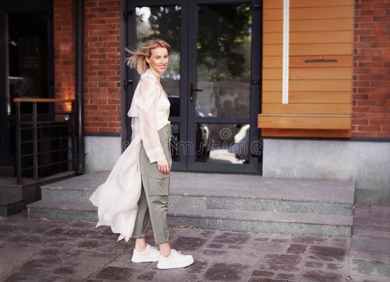 Vackra Fashion-modellen leende på City Street Strålningskoman med Fashionable Spring eller Strålrock för höstkläder. fotografering för bildbyråer Vackra Fashion-modellen leende på City Street Strålningskoman med Fashionable Spring eller Strålrock för höstkläder. fotografering för bildbyråer