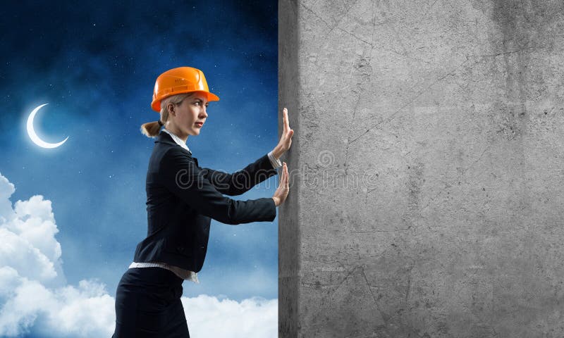 Vackra kvinnliga arkitekter som skjuter på betongväggen